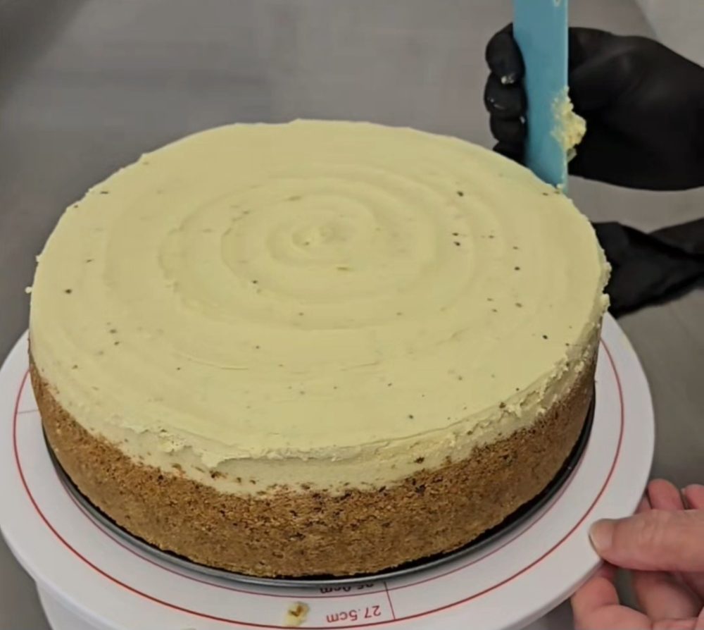 Frosting the Pistachio Cheesecake by hand in the APCC kitchen